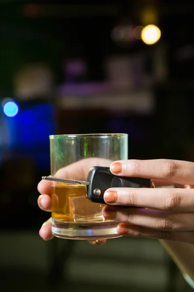 Woman holding a glass of whiskey and car keys — Stock Photo, Image