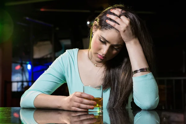 Mujer deprimida tomando whisky en el mostrador del bar — Foto de Stock