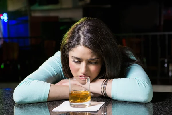 Mujer deprimida tomando whisky en el mostrador del bar —  Fotos de Stock