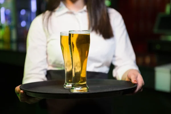 Barman servindo dois copos de cerveja — Fotografia de Stock