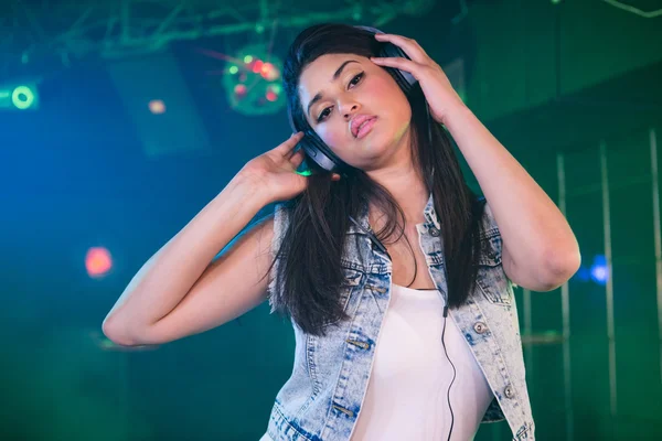 Pretty female DJ listening music on headphone — Stock Photo, Image