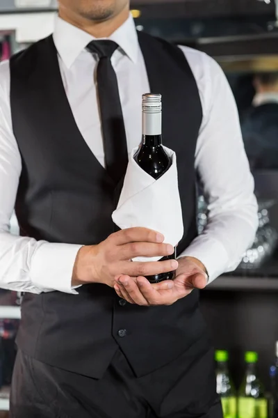 Средняя часть бармена держит бутылку вина — стоковое фото