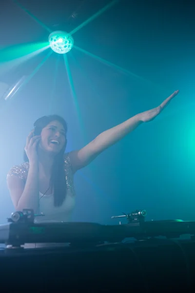 Jolie DJ féminine agitant la main tout en jouant de la musique — Photo