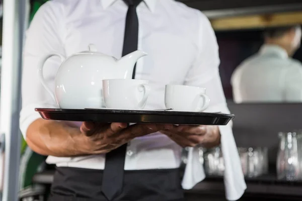 Mid section of waiter serving tea — Stock Photo, Image