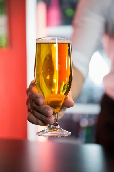 Barman servindo um copo de cerveja — Fotografia de Stock