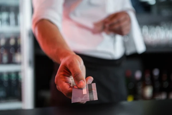 Barman acceptant une carte de crédit au comptoir du bar — Photo