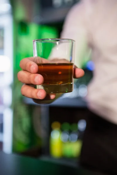 Бармен, подающий стакан виски — стоковое фото