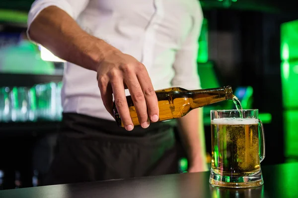 Mittelteil des Barkeeperers, der Bier in ein Glas gießt — Stockfoto