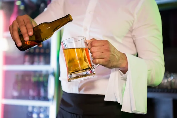 Barman derramando cerveja em uma caneca — Fotografia de Stock