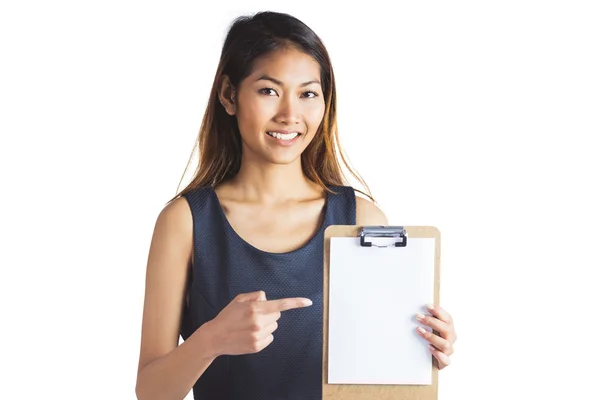 Smiling businesswoman pointing a clipboard — Stock Photo, Image