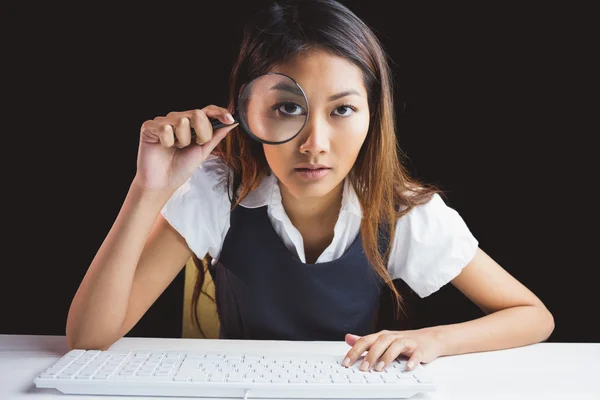 Businesswoman looking through magnifying glass — Stock Photo, Image