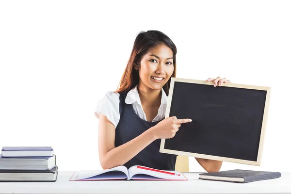 Empresária sorridente apontando um quadro negro — Fotografia de Stock