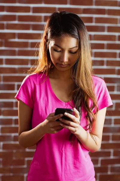 Concentrated asian woman using smartphone — Stock Photo, Image