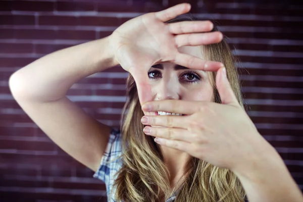 Jolie femme blonde regardant à travers ses mains — Photo