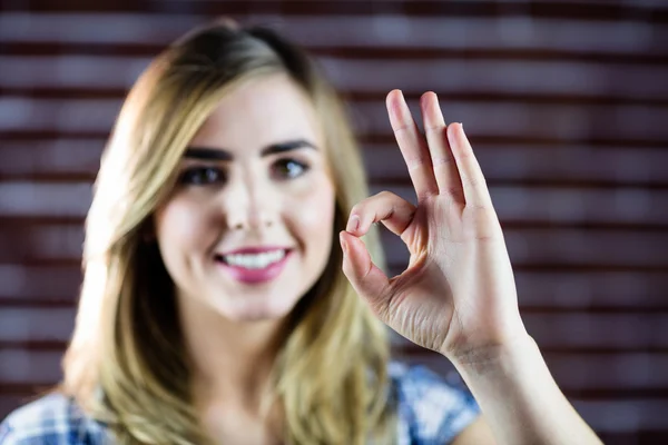 Mulher loira bonita fazendo sinais com os dedos — Fotografia de Stock
