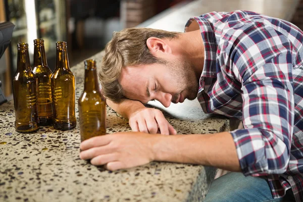 Erschöpfter Mann lehnt den Kopf auf dem Tresen — Stockfoto