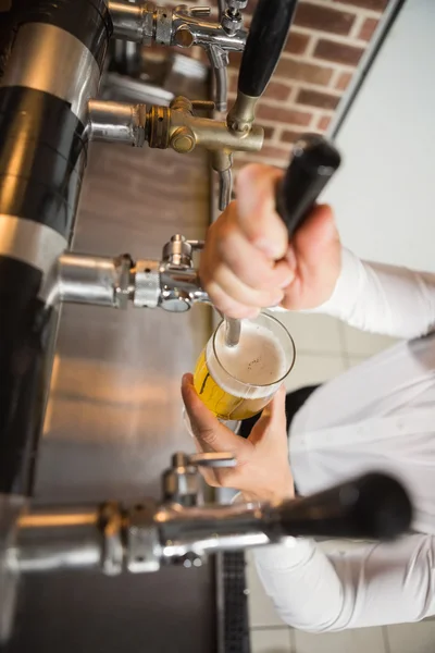 Barman pouring a pint of beer — Stock Photo, Image