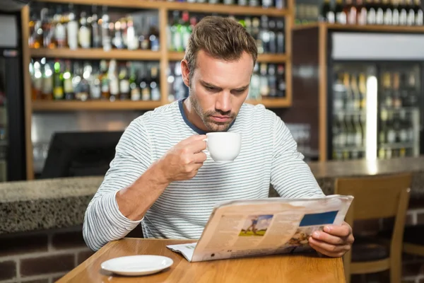 Uomo che legge il giornale e prende un caffè — Foto Stock