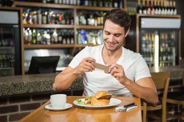 Hombre guapo tomando una foto de su comida — Foto de Stock