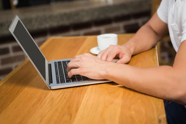 Knappe man laptop gebruikt en met koffie — Stockfoto