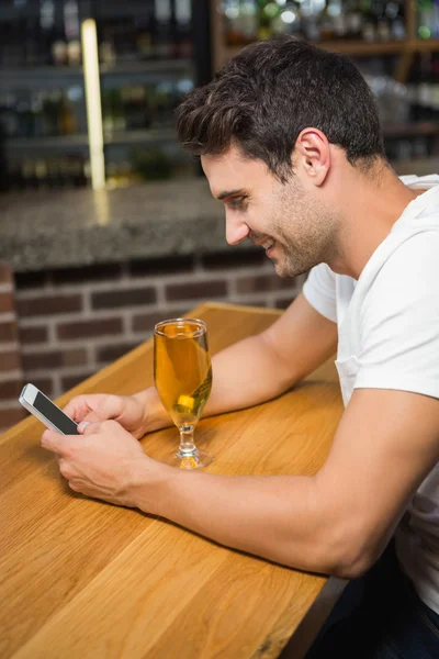Stilig man använder smartphone och med en öl — Stockfoto