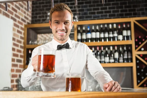 Handsome bar tender holding a pint — Stock Photo, Image