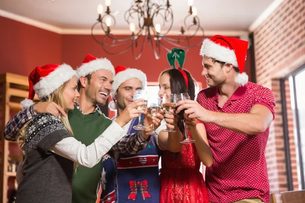 Niedliche Gruppe von Freunden, die mit Weihnachtsmützen anstoßen — Stockfoto