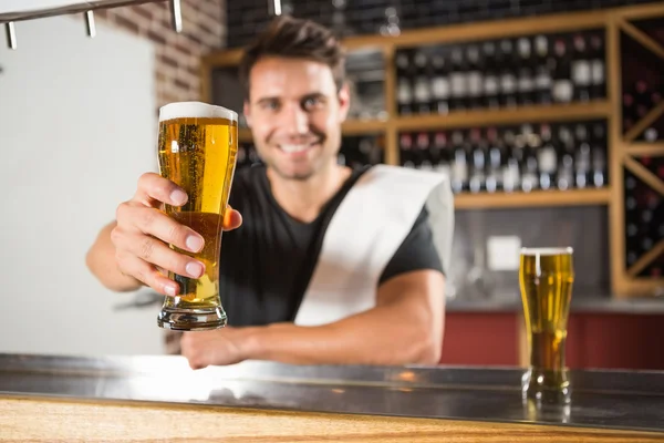 Bonito barman segurando uma caneca de cerveja — Fotografia de Stock