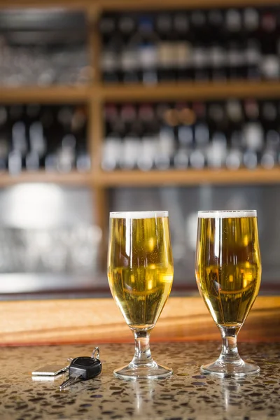 Weergave van twee pinten bier en auto sleutels — Stockfoto