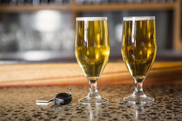 Weergave van twee pinten bier en auto sleutels — Stockfoto