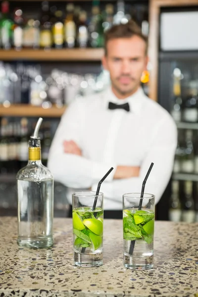 Knappe barman die achter cocktails — Stockfoto