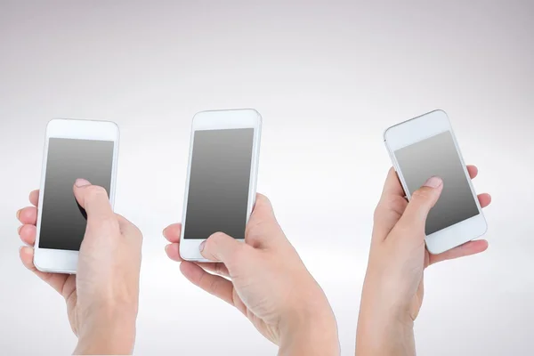 Tre mani che tengono gli smartphone — Foto Stock