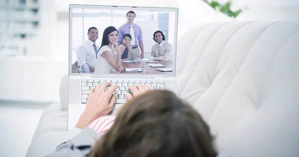 Woman using laptop lying on sofa — Stock Photo, Image