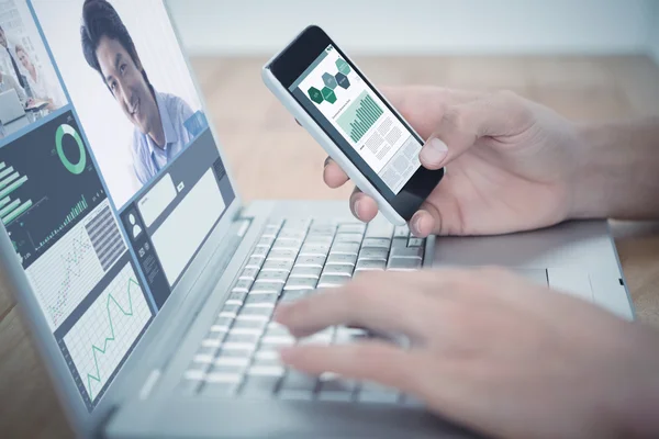 Man holding phone typing on laptop — Stock Photo, Image