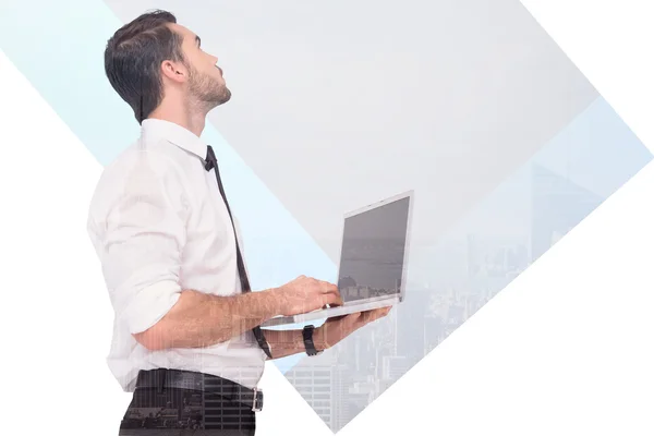 Composite image of sophisticated businessman standing using a la — Stock Photo, Image