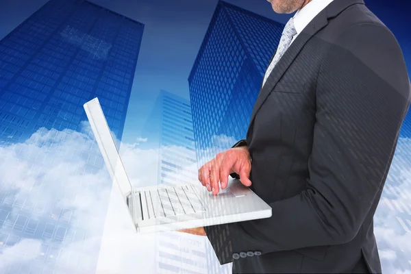 Samengestelde afbeelding van zakenman met laptop — Stockfoto