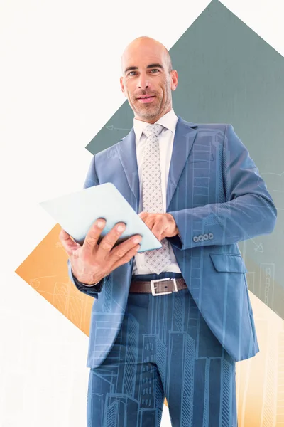 Composite image of businessman using a tablet and smiling at the — Stock Photo, Image