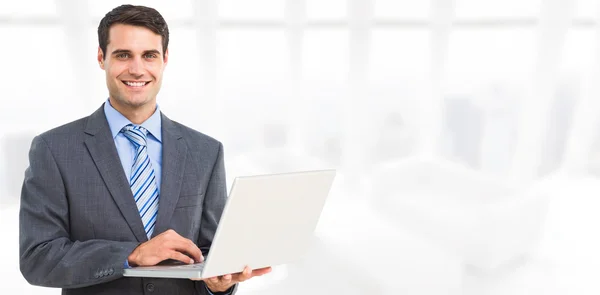 Hombre de negocios sonriente usando laptop — Foto de Stock