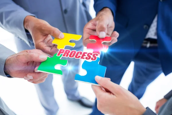 Business colleagues holding piece of puzzle — Stock Photo, Image