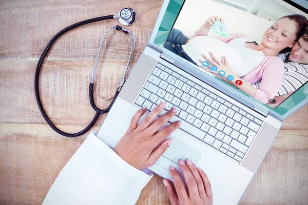 Médecin utilisant un ordinateur portable sur un bureau en bois — Photo