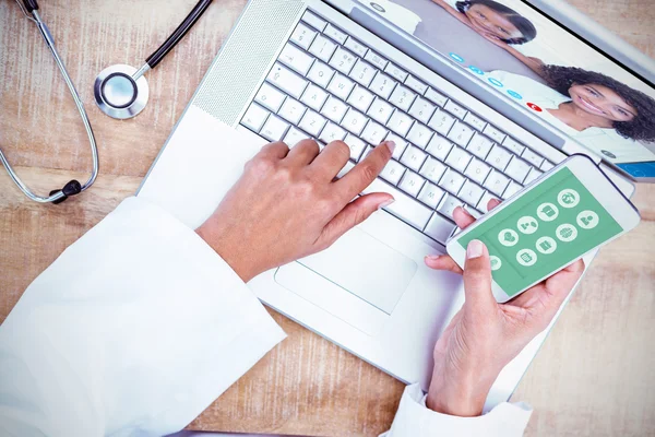 Doctor using smartphone on wooden desk — Stock Photo, Image