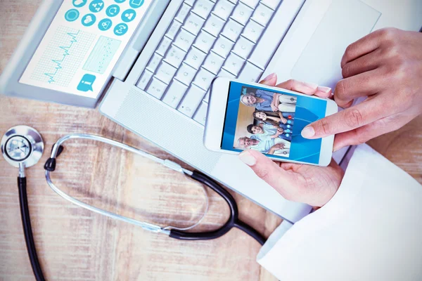 Médecin utilisant smartphone sur bureau en bois — Photo