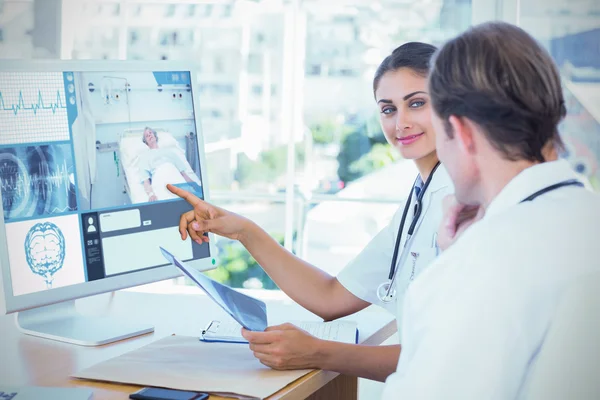 Arzt zeigt Kollegen den Bildschirm eines Computers — Stockfoto