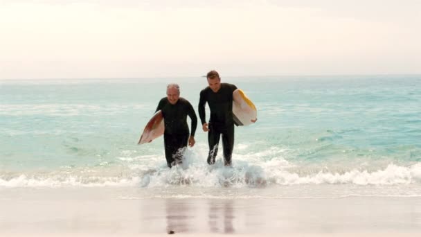 Hombres con tablas de surf corriendo — Vídeos de Stock