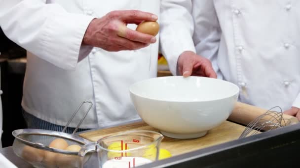 Шеф-повар разбивает яйцо в миску — стоковое видео
