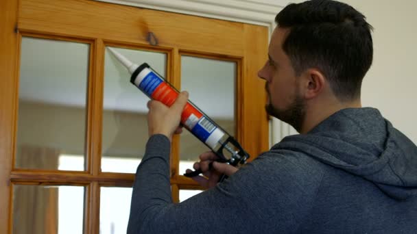 Handyman rellenando azulejos a puerta — Vídeos de Stock