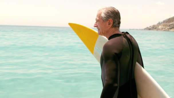 Старший мужчина с позированием доски для серфинга — стоковое видео