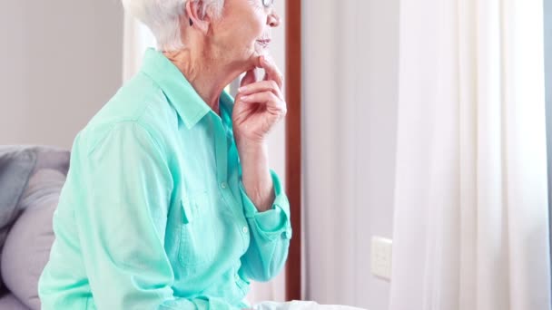 Mujer mayor mirando por la ventana — Vídeos de Stock