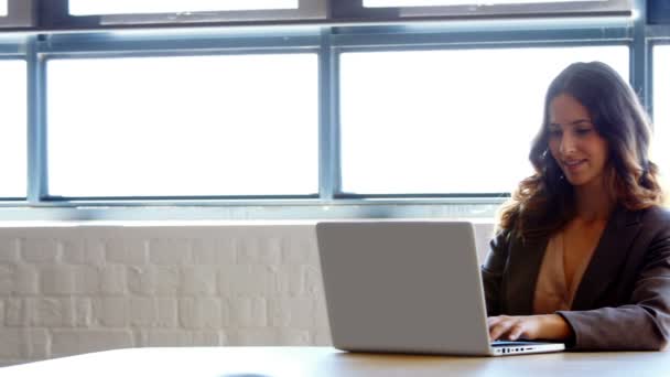 Empresaria usando su laptop en el trabajo — Vídeos de Stock