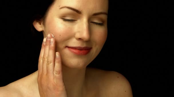 Mujer sonriente aplicando crema — Vídeos de Stock